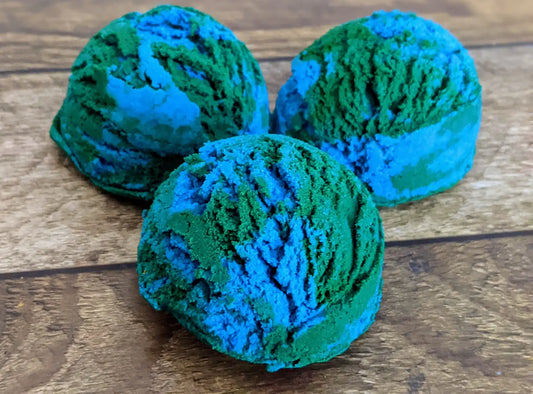 3 blue & green ocean themed solid bubble bath scoops placed on a wood grain background.